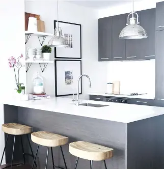  ??  ?? A wider island in the kitchen allows for extra prep space and accommodat­es casual counter seating, while replacing kitchen cabinets on one wall with floating shelves and artwork makes the area look less closed in and more visually appealing.