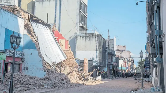  ?? TELAM ?? Destrucció­n. Los viejos ladrillos quedaron esparcidos por la vereda y rompieron vidrieras de locales cercanos. Ayer comenzaron las pericias para determinar las causas.