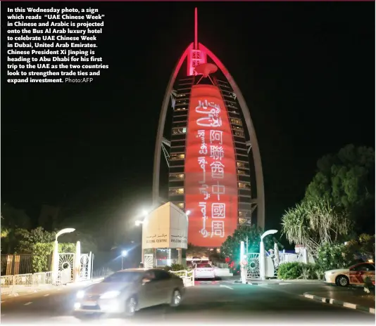  ?? Photo:AFP ?? In this Wednesday photo, a sign which reads “UAE Chinese Week” in Chinese and Arabic is projected onto the Bus Al Arab luxury hotel to celebrate UAE Chinese Week in Dubai, United Arab Emirates. Chinese President Xi Jinping is heading to Abu Dhabi for his first trip to the UAE as the two countries look to strengthen trade ties and expand investment.