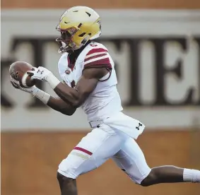  ?? Ap photo ?? FLYING: Jeff Smith heads for the end zone with one of five touchdown passes thrown by Anthony Brown in Boston College’s 41-34 victory against Wake Forest last night; (top left) the Eagles defense celebrates a turnover, while (left) BC got another big ground game from AJ Dillon.