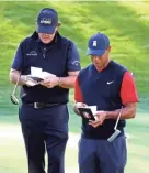  ?? ROB ?? Phil Mickelson, left, and Tiger Woods check their yardage books Friday at Shadow Creek Golf Course.