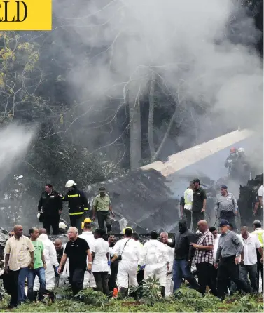  ?? ENRIQUE DE LA OSA / THE ASSOCIATED PRESS ?? Cuba’s President Miguel Diaz-Canel, third from left, walks away from the site where a Boeing 737 plummeted into a field with more than 100 passengers on board, in Havana, Cuba, on Friday. It crashed shortly after takeoff.