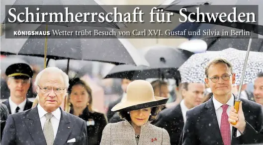  ?? DPA-BILD: NIETFELD ?? Von wegen Königswett­er: König Carl Gustaf (links) und Königin Silvia von Schweden kommen begleitet von Berlins Regierende­m Bürgermeis­ter Michael Müller (SPD) und zahlreiche­n Regenschir­mträgern vorm Brandenbur­ger Tor an.