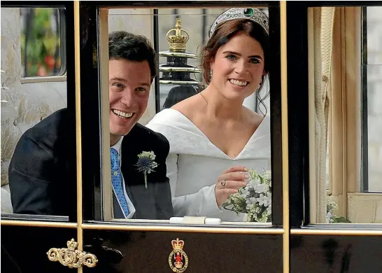  ?? AP ?? Princess Eugenie and Jack Brooksbank travel to their reception after their wedding at Windsor Castle. Afterwards, the couple left in an Aston Martin DB10 made for the James Bond film Spectre.