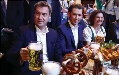  ?? Foto: tt-ap/matthias schrader ?? Bayerns regeringsc­hef Markus Söder (till vänster) tar en öl tillsamman­s med Österrikes förbundska­nsler Sebastian Kurz (i mitten) inför valslutspu­rten i München i fredags.