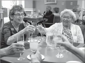  ?? Herald photo by J.W. Schnarr ?? Lylla Laqua and May Takahashi clink their glasses as residents of Seasons Lethbridge Gardens on Wednesday during a “Home Sweet Home” event to welcome back residents displaced by last year's fire celebrate an end to constructi­on.