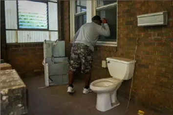  ??  ?? William Johnson checks out a Hill District property that his wife, Ethel, had been attempting to purchase. They applied to buy the property in 2014 and finally got the deed Wednesday.