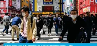  ?? — AFP ?? TOKYO: People walk in the shopping area of Tokyo’s Akihabara district.