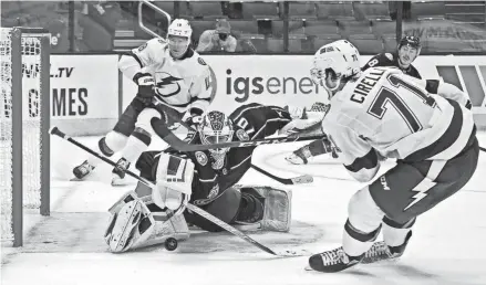  ?? KYLE ROBERTSON/COLUMBUS DISPATCH ?? Joonas Korpisalo (70) makes a save against Tampa Bay Lightning center Anthony Cirelli (71) in overtime Thursday night. It was one of his 34 saves in the game.