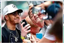  ?? GETTY/AFP ?? Charm offensive: Hamilton plays to the crowd at Silverston­e yesterday following his Trafalgar Square no-show and (above) greets fans