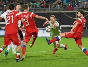  ?? — Reuters ?? Caught in the middle: Germany’s Manuel Neuer in action with Russia’s Georgi Dzhikiya and Roman Neustadter during their friendly match on Thursday.