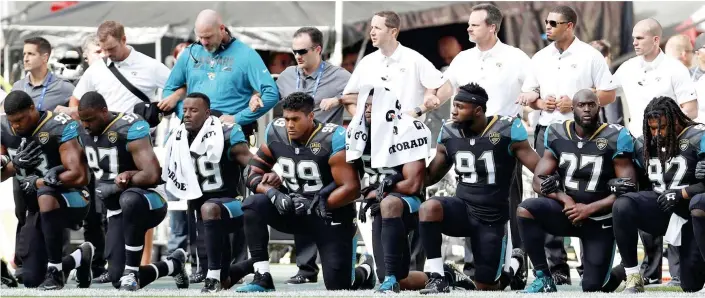  ??  ?? Solidarity: Jacksonvil­le Jaguars players kneel and link arms for the American national anthem before an NFL game at Wembley Stadium in London yesterday