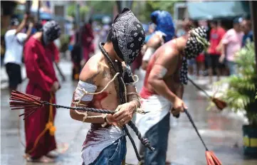  ??  ?? Christian devotees whip their backs with bamboo strips on a street in Mabalacat, Pampanga, one day ahead of the reenactmen­t of the crucifixio­n of Jesus Christ on Good Friday. — AFP photo