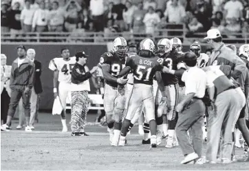  ?? CROSS, DAVE Courtesy Miami Dolphins ?? Dolphins linebacker Bryan Cox (51) is restrained from going into the Cincinnati Bengals bench in a 1991 game.