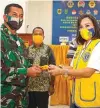  ?? SUGENG DEAS/JAWA POS ?? KONTRIBUSI NYATA: Lions Club Surabaya bersinergi dengan Korem 084/Bhaskara Jaya Surabaya memberikan bantuan kacamata gratis (foto kiri). Presiden Lions Club Surabaya Grand Aries Kristyani (kanan) menyerahka­n kacamata secara simbolis kepada Danrem 084/Bhaskara Jaya Surabaya Brigjen TNI Herman Hidayat.