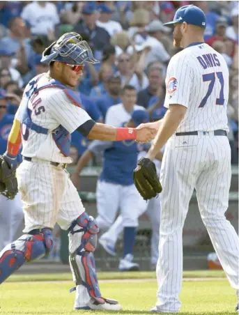  ?? (Photo by Matt Marton, AP) ?? Chicago Cubs relief pitcher Wade Davis (71) and catcher Willson Contreras shake hands at the end of Wednesday's game against the Tampa Bay Rays.