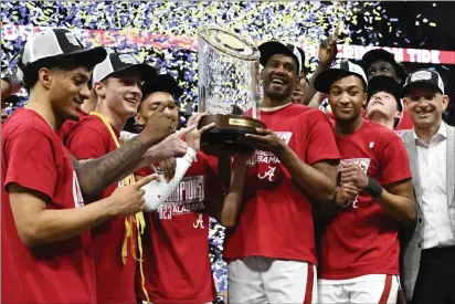  ?? JOHN AMIS — THE ASSOCIATED PRESS ?? Alabama players pose with the trophy after a game against Texas A&M in the finals of the Southeaste­rn Conference Tournament on Sunday in Nashville, Tenn.
