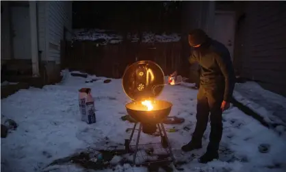 ?? Photograph: Mikala Compton/Reuters ?? Max King cooks a pizza on a charcoal grill after winter weather caused electricit­y blackouts in San Marcos, Texas, on 17 February 2021.