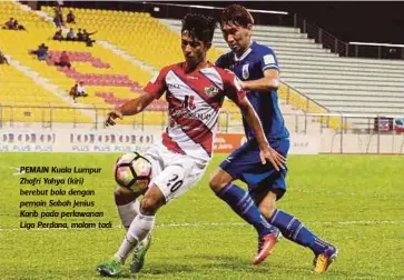  ?? FOTO: ?? PEMAIN Kuala Lumpur Zhafri Yahya (kiri) berebut bola dengan pemain Sabah Jenius
Karib pada perlawanan Liga Perdana, malam tadi.