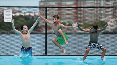  ?? MATT STONE PHOTOS / HERALD STAFF ?? KEEP COOL: Owen Flanagan of Eastie, Zachary Spencer of Jamaica Plain and his brother Jacob Spencer jump into the Mirabella Pool in the North End Tuesday. Anne Shaw of Malden, meanwhile, catches up with some reading in Southie’s Pleasure Bay. And top right, Lucy, 3, relaxes in the Frog Pond on the Common.