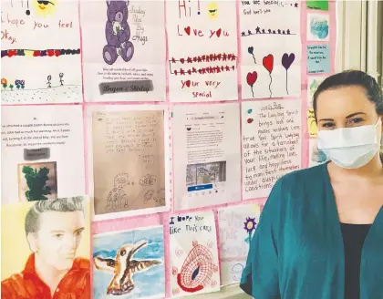  ?? JILLYAN CLARK ?? Jillyan Clark, recreation co-ordinator at the Qu’appelle House Seniors Care Home in Regina, stands in front of the ‘joy wall’ covered in art that children — and some adults — in the community have sent to cheer up the home’s residents as part of a new pen pal program.