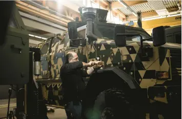  ?? JIM HUYLEBROEK/THE NEW YORK TIMES ?? A mechanic works on a German-made Dingo reconnaiss­ance vehicle Feb. 9 at a military facility in Luxembourg. With a limited military arsenal on hand, the tiny country is instead using its money to help arm Ukraine.