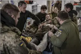  ?? FINBARR O'REILLY — THE NEW YORK TIMES ?? A Ukrainian soldier with a bullet wound to the leg receives treatment at a stabilizat­ion point near the frontline in Ukraine's eastern Donetsk region on Monday.