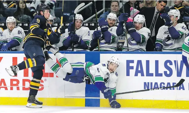  ?? — AP PHOTO ?? The Sabres’ Jack Eichel sends Canucks forward Brendan Leipsic flying during third-period action in Buffalo Saturday afternoon.