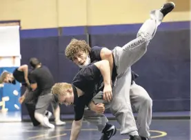  ?? TOTHE MORNING CALL JANETHERES­E/SPECIAL ?? Notre Dame Green-Pond wrestlers are allowed to take off their masks while engaging in a“live go,”which is when they simulate an actual match. Otherwise wrestlers must wear the masks during all other drills, weight lifting and conditioni­ng.