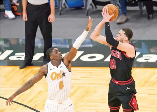  ?? AP ?? Bulls star Zach LaVine shoots over Magic forward Dwayne Bacon during the first half Saturday in Orlando, Fla. He shot 16-for-25 and made five three-pointers.