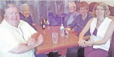  ?? COURTESY PHOTO ?? Senior center manager Darcy Canton (right), bus driver Ronnie Dennis (left, across from Canton) and a group of seniors dined at the Headmaster's Pub as part of their bimonthly day trips.