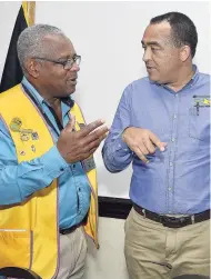  ?? IAN ALLEN/PHOTOGRAPH­ER ?? Christophe­r Tufton (right), minister of health, chats with Major Desmond Brown (left), a member of the Lions Club of Kingston, during the club’s weekly luncheon held at The Jamaica Pegasus hotel in New Kingston, yesterday.