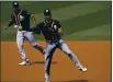  ?? PHOTO BY HARRY HOW — GETTY IMAGES ?? Oakland A’s Chad Pinder throws out Houston Astros’ George Springer at first base as teammate Marcus Semien looks on during the first inning in Game 4 of their ALDS at Dodger Stadium on Thursday in Los Angeles.