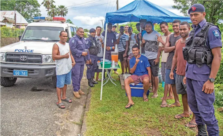  ?? Photo: Leon Lord ?? Bringing the peace… Police officers with some residents of Sukanaivau Rd in Nabua on April 5, 2021, following the brawl that took place during the Easter break. ACP Abdul Khan had mentioned how people needed to change their mindset of what the Public Rental Board’s Mead Road estate is known for and work towards building a better future for the residents.