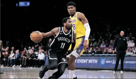  ?? (P PHOTO/COREY SIPKIN ?? Brooklyn Nets guard Kyrie Irving (11) drives past Los Angeles Lakers forward Rui Hachimura (28) during the first half of an NBA basketball game on Monday in New York.