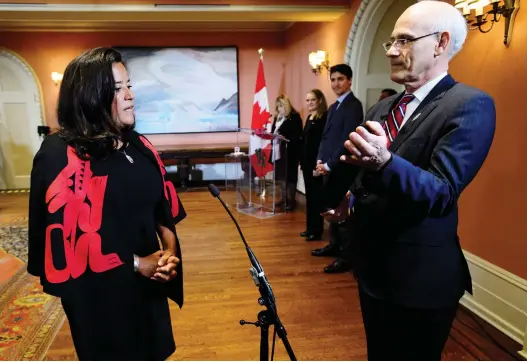  ?? SEAN KILPATRICK / THE CANADIAN PRESS FILES ?? Prime Minister Justin Trudeau looks on from the background in January as Jody Wilson-Raybould is sworn in as veterans affairs minister at Rideau Hall in Ottawa.