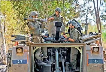  ?? AFP ?? Israeli troops prepare to launch a mortar on the Gaza Strip, from the southern Israel along the border with the Palestinia­n enclave, on Friday. —
