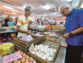  ?? BERNAMA PIC ?? Domestic Trade, Cooperativ­es and Consumeris­m Minister Datuk Seri Hamzah Zainudin checking the prices of goods at the Plaza Perbandara­n wet market in Taiping yesterday.