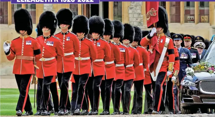  ?? ?? Weight of responsibi­lity: With flawless precision, the Grenadier Guards in their striking red uniforms and bearskin hats escort the coffin of Queen Elizabeth II, aboard the flower-adorned state hearse, inside Windsor Castle ahead of the committal service yesterday