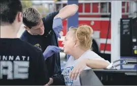  ?? John Minchillo Associated Press ?? MEDICS with the Cincinnati Fire Department nasally administer naloxone to a woman while responding to a possible overdose at a gas station in the city.