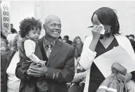  ??  ?? Bridget Williams wipes away tears as Arthur Williams holds their son, Alexander Williams, 2, during an adoption ceremony at the Baltimore Circuit Court.