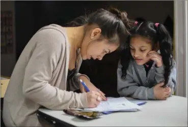  ?? ERIC BONZAR — THE MORNING JOURNAL ?? Childcare worker Karelin Medina Del-Valle, 21, helps 8-year-old Vilma Nievez with her homework at Rita’s Christian Academy, March 7.