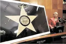  ?? Gary Coronado / Houston Chronicle ?? Mayor Annise Parker displays a 1915 prototype for the Houston flag. Preservati­on Houston helped raise cash to restore it.