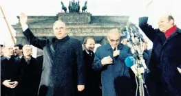  ?? AP ?? In this Dec. 22. 1989, photo, West German chancellor Helmut Kohl, left, waves as he stands with then-East German Prime Minister Hans Modrow, second from right.
