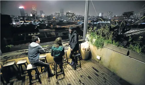  ?? Picture: Alaister Russell ?? Lorenzo Dal Col, Cherie Beack and Njabulo Skhosana enjoy the view at The Living Room rooftop bar at Maboneng Precinct, Johannesbu­rg.