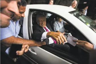  ?? Moises Castillo / Associated press ?? Mexico’s President-elect Andres Manuel Lopez Obrador receives a note as he leaves his headquarte­rs in Mexico City. Each day hundreds of Mexicans crowd outside his office.