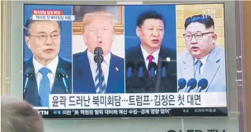  ??  ?? People watch a screen showing images of (from left) Moon, Trump, Xi, and Kim at a railway station in Seoul. The US-North Korea summit will take place in Singapore.