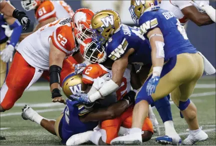  ?? The Canadian Press ?? BC Lions’ Chris Rainey runs into the Blue Bombers’ Jovan Santos-Knox during the second half of CFL action in Winnipeg on Saturday.