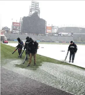  ?? DAVID ZALUBOWSKI/THE ASSOCIATED PRESS ?? Staffers clear light snow froms Coors Field before the Colorado Rockies’ home opener against the Atlanta Braves Friday in Denver.