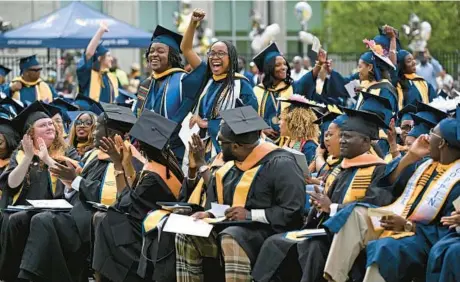  ?? KIM HAIRSTON/BALTIMORE SUN PHOTOS ?? Coppin State University graduates cheer Friday during commenceme­nt at the Physical Education Complex Field.